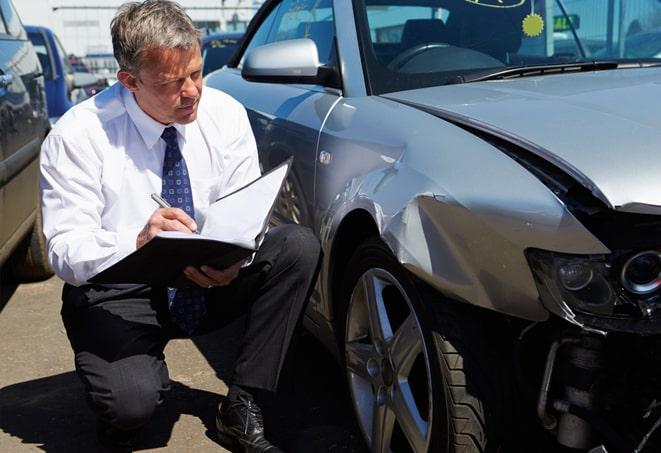 man comparing auto insurance quotes on laptop